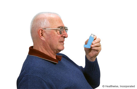 Un hombre sosteniendo el inhalador en posición vertical