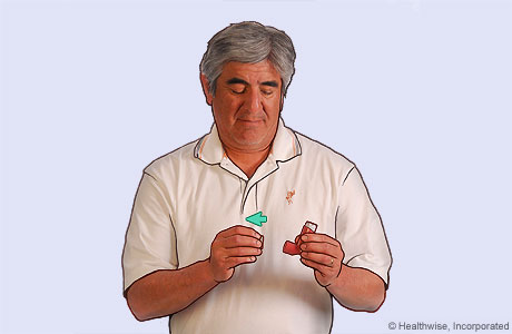 Foto de un hombre retirando la tapa de un inhalador