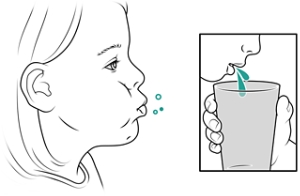 Child rinsing mouth and spitting into cup.
