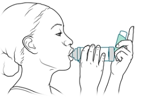 Persona con la boquilla de la cámara de inhalación en la boca.