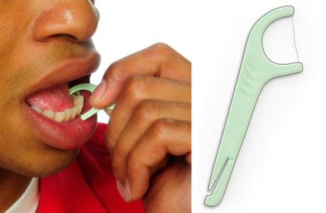 Persona utilizando un instrumento para usar el hilo dental, moviéndolo hacia arriba y hacia abajo entre dos dientes.