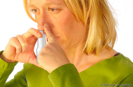 Mujer usando un aerosol nasal