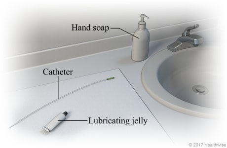 Bathroom sink area, showing hand soap, catheter, lubricating jelly, and mirror on clean cloth.