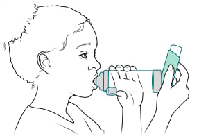 Niño con los labios bien cerrados alrededor de la boquilla de la cámara de inhalación.