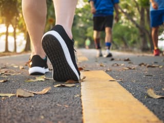 Person wearing sport shoes walking along outdoor path