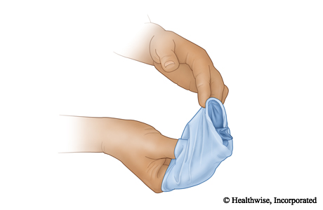 Pull the second glove off over the balled-up glove.