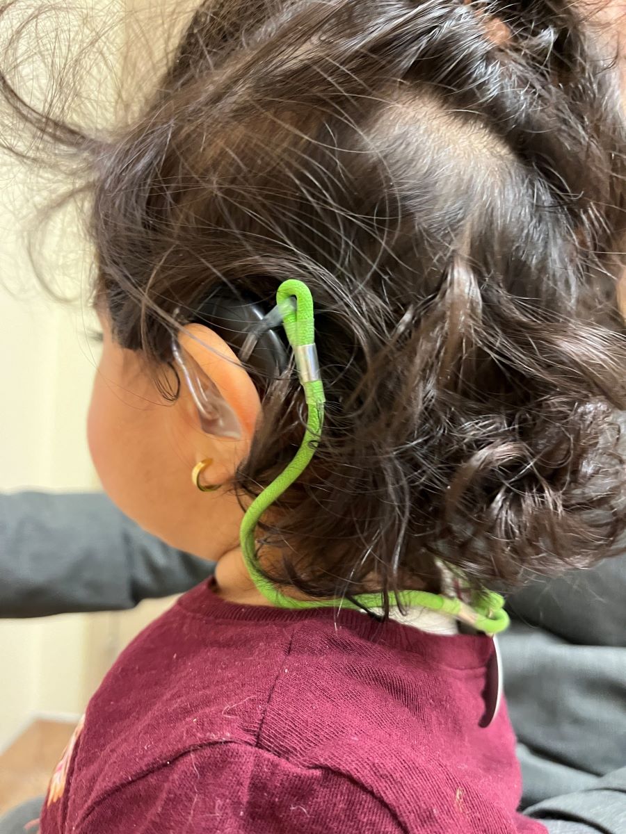 girl with hearing aid cord