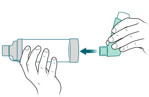 Mouthpiece of inhaler being placed into spacer.