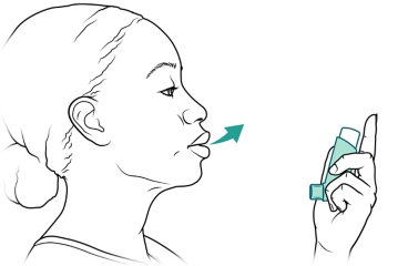 Persona sosteniendo el inhalador y exhalando.