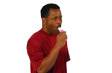 Hombre colocándose el inhalador en la boca